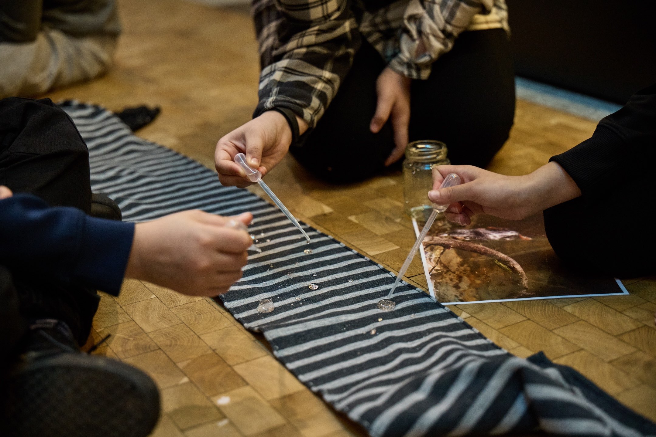 people doing an experiment with a pipette and a cloth 